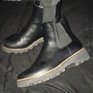 all black chelsea boots with gold chain accent